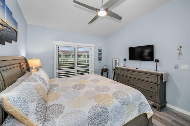 bedroom featuring a ceiling fan, wood finished floors, baseboards, lofted ceiling, and access to outside