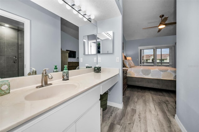 full bathroom with vanity, wood finished floors, ensuite bath, a stall shower, and vaulted ceiling