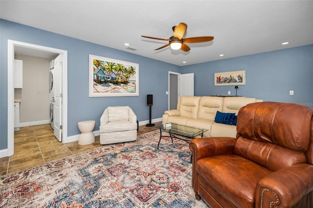 living area featuring stacked washer / dryer, recessed lighting, a ceiling fan, and baseboards