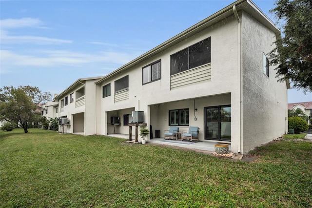 back of property featuring a patio, cooling unit, a lawn, and stucco siding