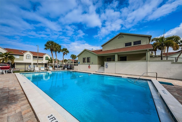 pool with a patio and fence