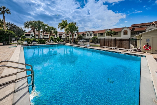 pool with a residential view, a patio, and fence