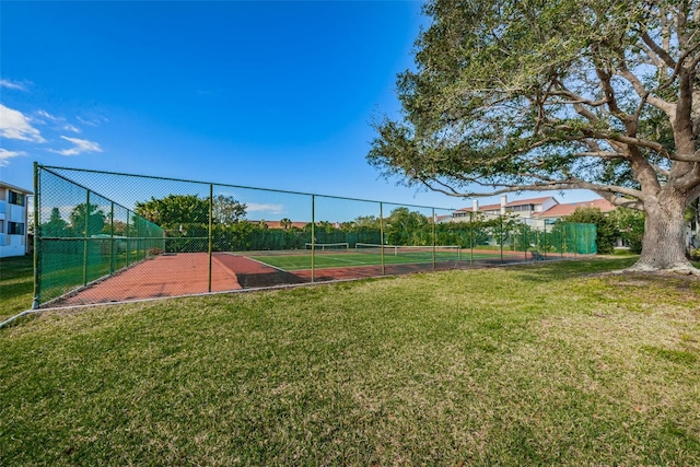 exterior space featuring a tennis court, a yard, and fence