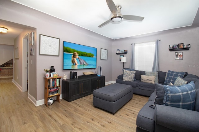 living area with baseboards, light wood-style floors, and ceiling fan