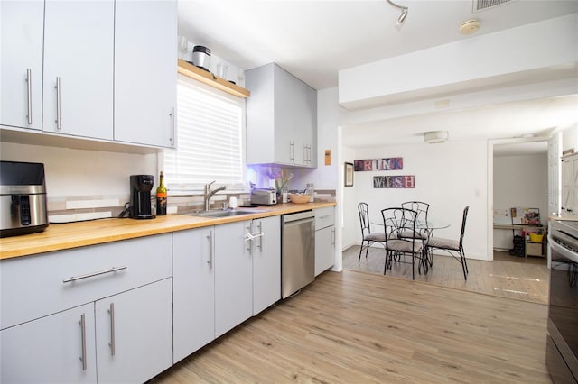 kitchen featuring light wood-style flooring, stainless steel appliances, wood counters, and a sink