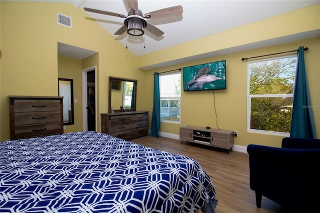 bedroom with visible vents, baseboards, vaulted ceiling, wood finished floors, and a ceiling fan