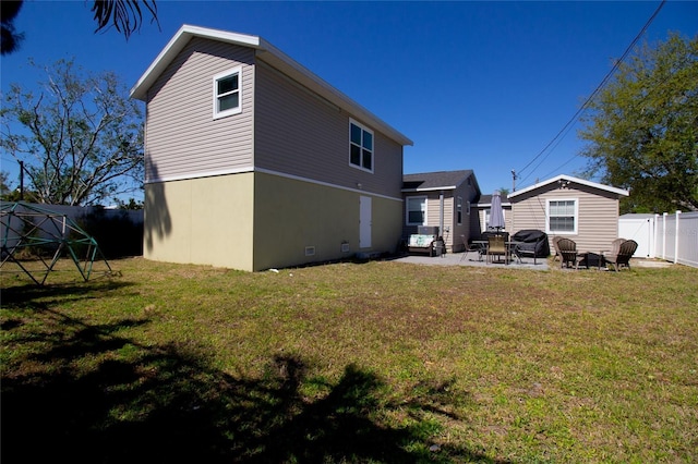 back of house with a patio area, a lawn, and a fenced backyard