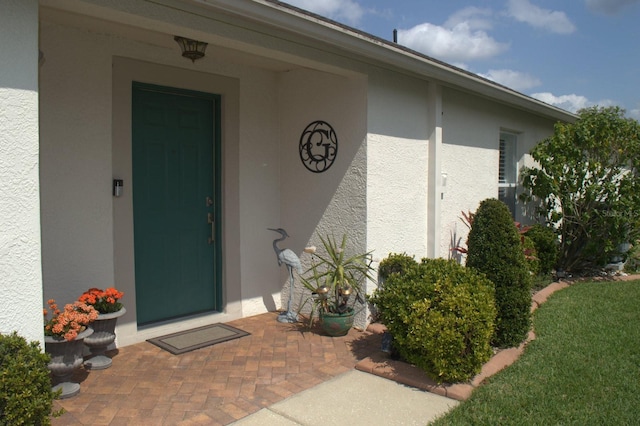 doorway to property featuring stucco siding