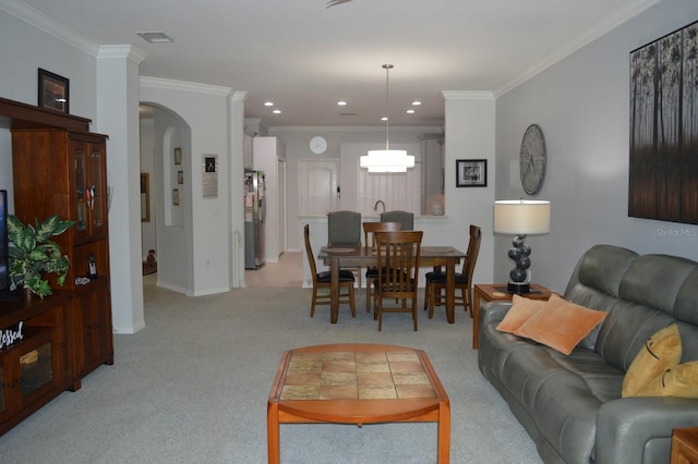 living room featuring recessed lighting, arched walkways, light colored carpet, and ornamental molding