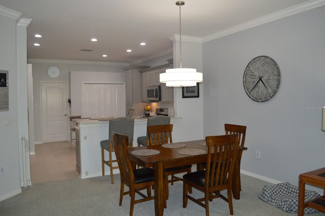 dining room with recessed lighting, light colored carpet, baseboards, and ornamental molding