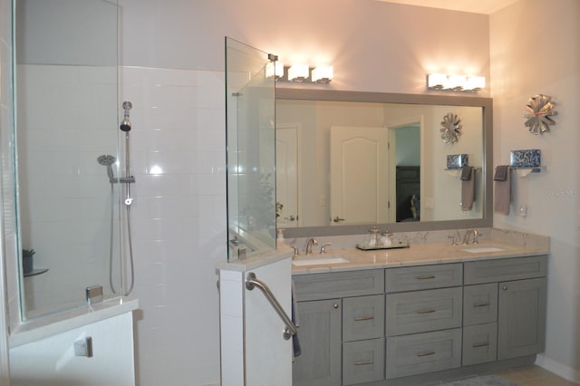 full bathroom featuring double vanity, walk in shower, and a sink