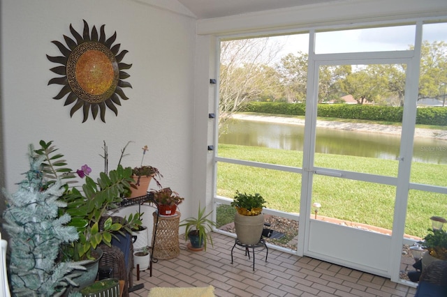 sunroom featuring a water view