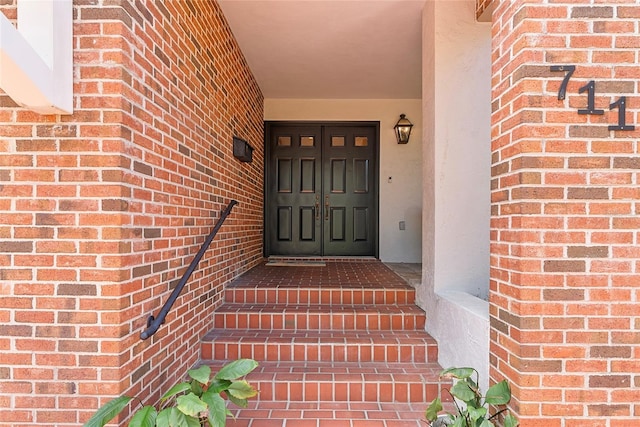 entrance to property featuring brick siding