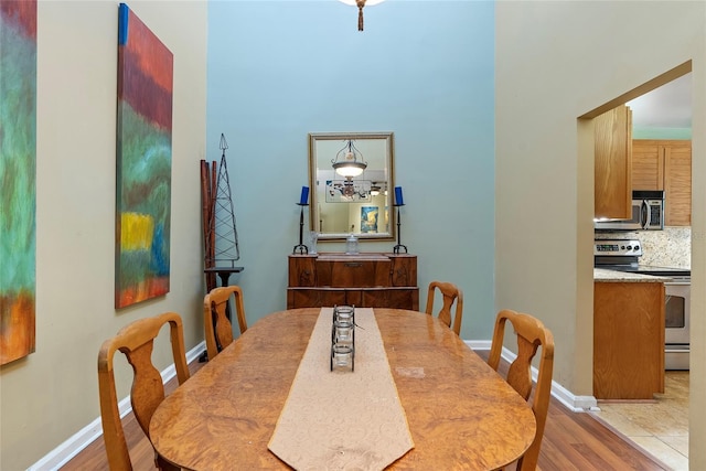 dining space featuring light wood-type flooring and baseboards