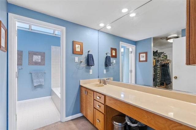 bathroom featuring vanity, baseboards, recessed lighting, a tub, and a shower