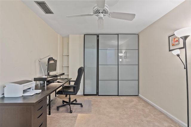 home office with visible vents, baseboards, light colored carpet, and ceiling fan