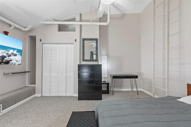 bedroom with a closet, baseboards, carpet flooring, and vaulted ceiling