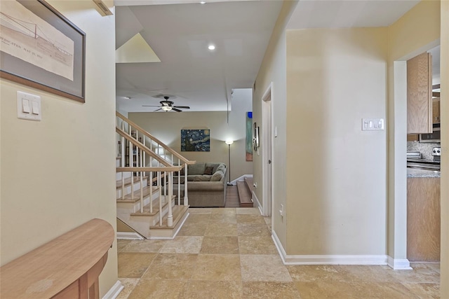 hallway with stone finish flooring, stairs, and baseboards