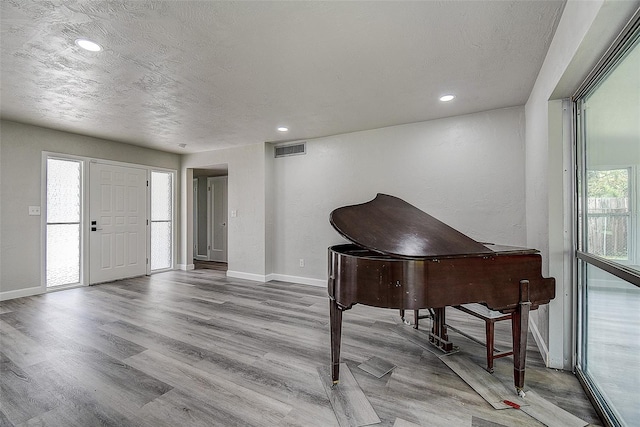 entryway featuring visible vents, a textured ceiling, wood finished floors, recessed lighting, and baseboards