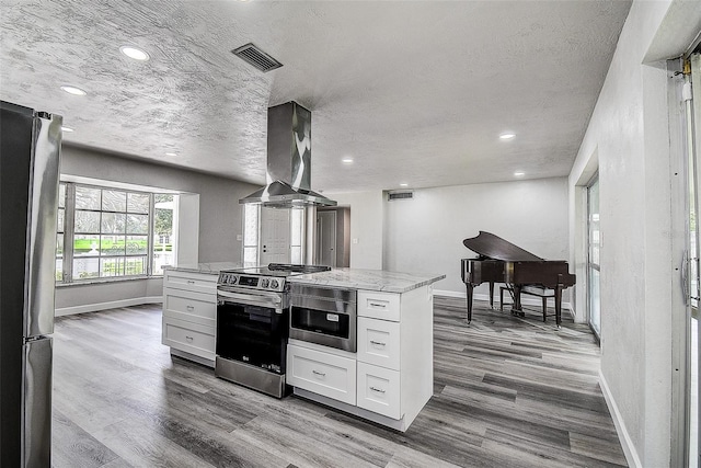 kitchen with dark wood finished floors, light stone counters, island exhaust hood, stainless steel appliances, and white cabinetry