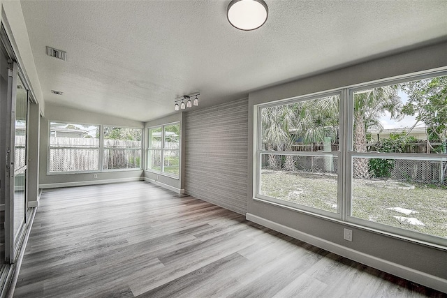 unfurnished sunroom with visible vents and track lighting