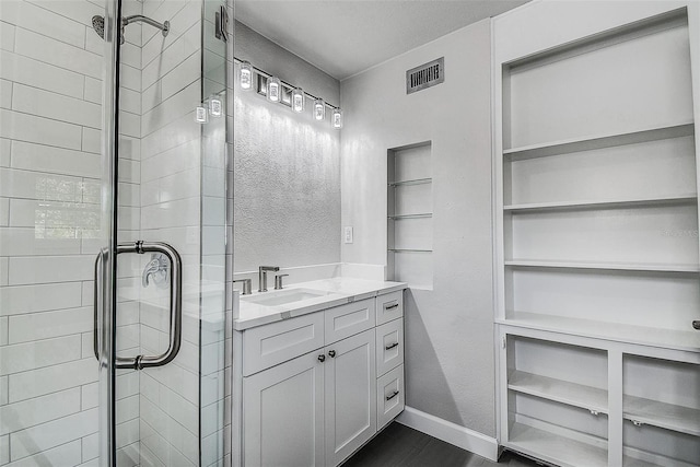 full bath featuring visible vents, baseboards, vanity, and a shower stall