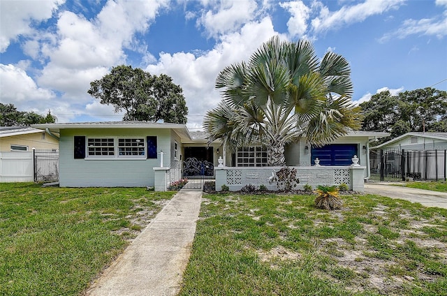 view of front facade with a front lawn, fence, and driveway