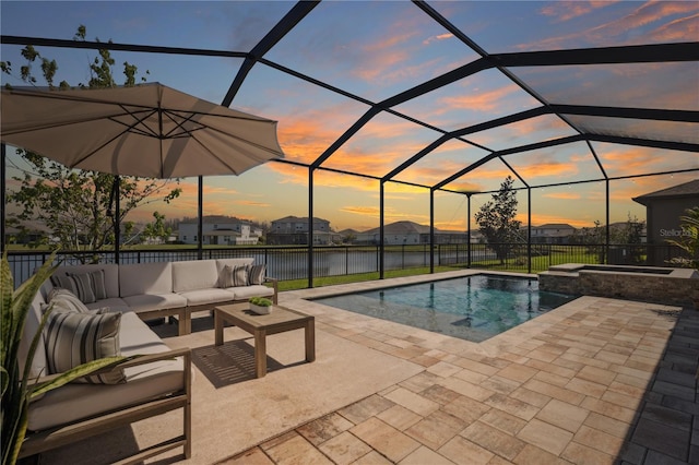 pool at dusk featuring a patio area, an outdoor hangout area, a pool with connected hot tub, and a lanai