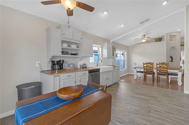 kitchen featuring light wood finished floors, visible vents, a sink, dishwasher, and open shelves