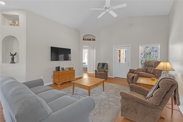 living area featuring a wealth of natural light, baseboards, and wood finished floors