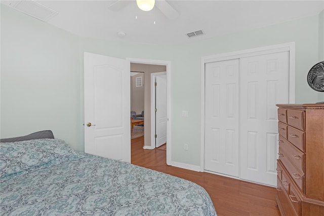 bedroom featuring a closet, visible vents, a ceiling fan, and wood finished floors