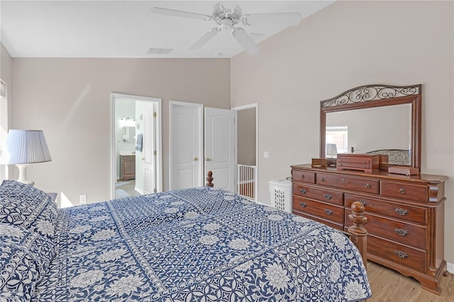 bedroom with visible vents, lofted ceiling, light wood-style flooring, ensuite bathroom, and a ceiling fan