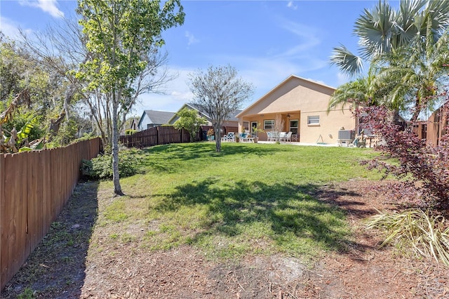 view of yard with a patio area, central AC unit, and fence