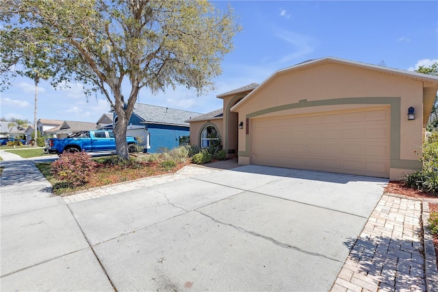 view of front facade featuring stucco siding, an attached garage, and driveway