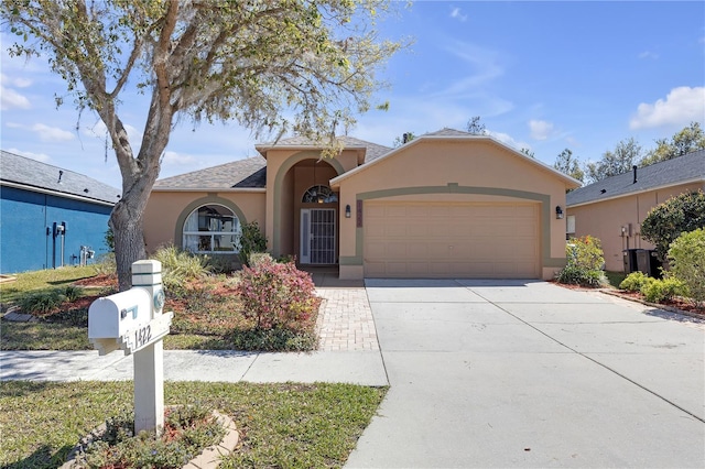 view of front of house with a garage, driveway, and stucco siding