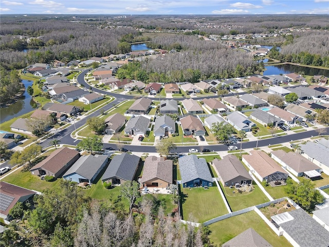 aerial view with a view of trees, a water view, and a residential view