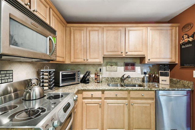 kitchen with light brown cabinets, a toaster, decorative backsplash, appliances with stainless steel finishes, and a sink