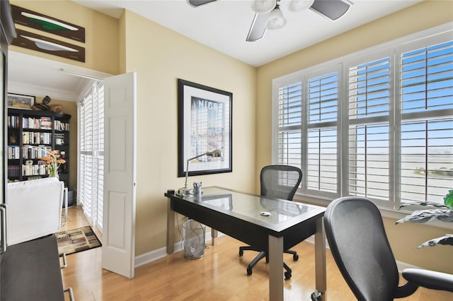 office space featuring a ceiling fan, wood finished floors, baseboards, and a wealth of natural light