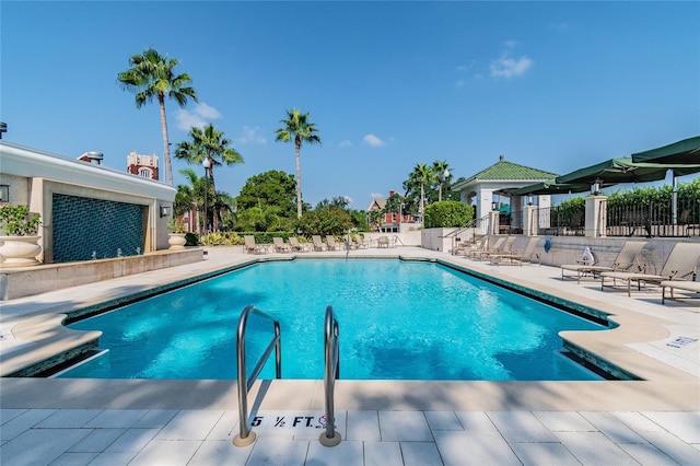 pool featuring fence and a patio area