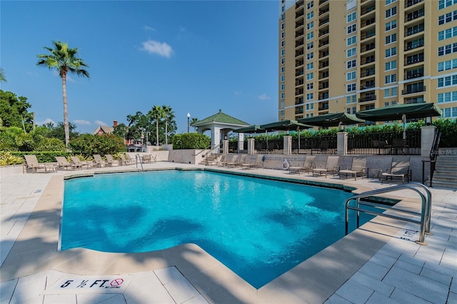 pool with a patio area and fence