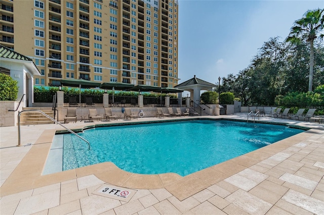 community pool featuring a patio and fence