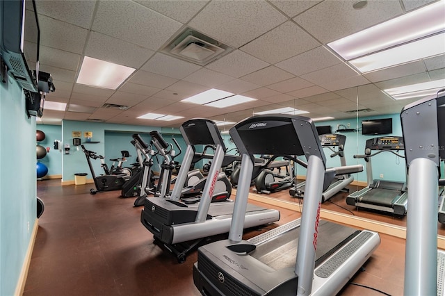 workout area featuring baseboards, visible vents, and a drop ceiling