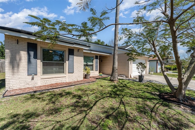 view of front of home featuring concrete driveway, a garage, brick siding, and a front yard