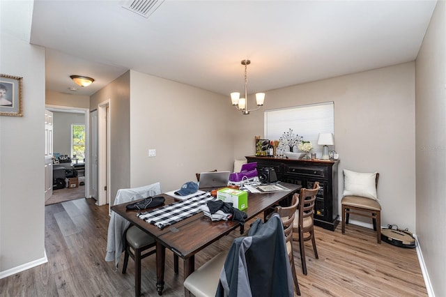 dining room with baseboards, visible vents, a chandelier, and light wood-type flooring