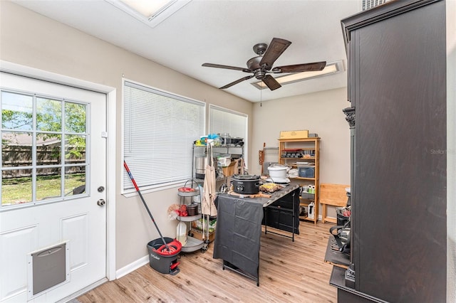 office space with baseboards, light wood-style floors, and a ceiling fan