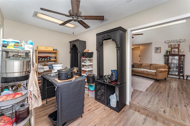 office area with visible vents, light wood finished floors, and ceiling fan