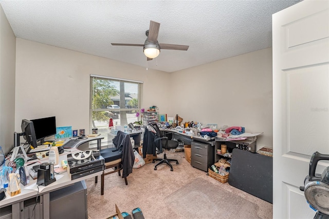 home office with ceiling fan, carpet floors, and a textured ceiling