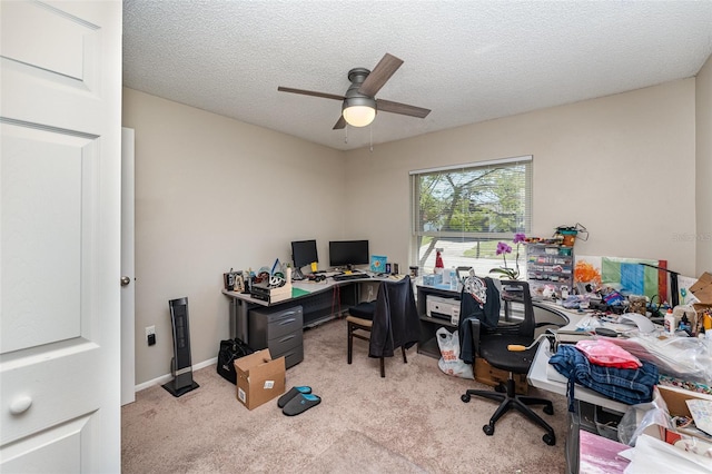 carpeted office featuring baseboards, a textured ceiling, and ceiling fan