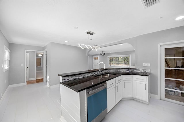 kitchen with visible vents, white cabinetry, arched walkways, a sink, and dishwasher