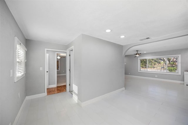 unfurnished room with visible vents, baseboards, recessed lighting, arched walkways, and a ceiling fan